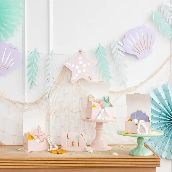 Decorative setup with pastel-colored items and party decorations Mermaid Banner Garland