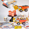 Construction-themed party supplies including cups, plates, and a toy dump truck on a white background.
